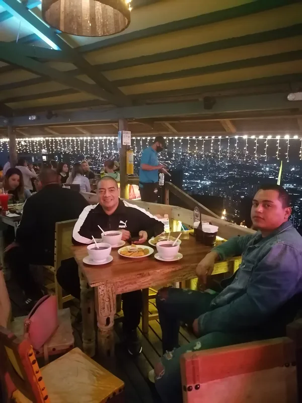 Cena en un restaurante con vista nocturna de la ciudad