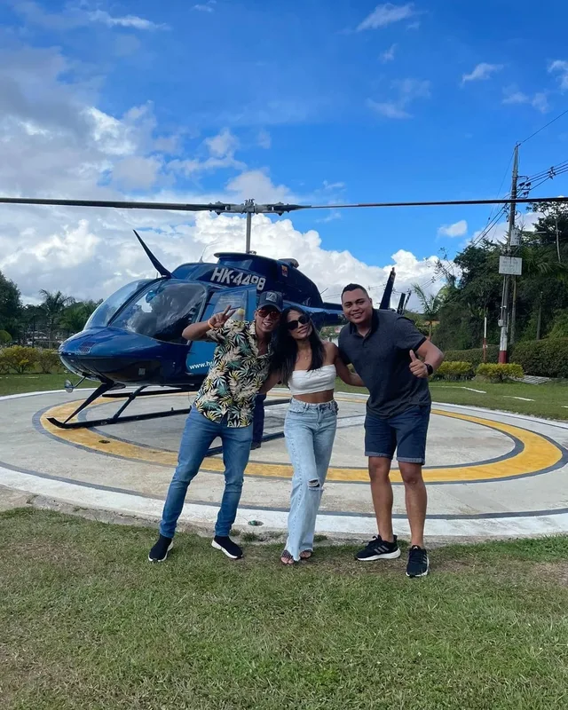 Tres viajeros junto a un helicóptero antes de sobrevolar la región